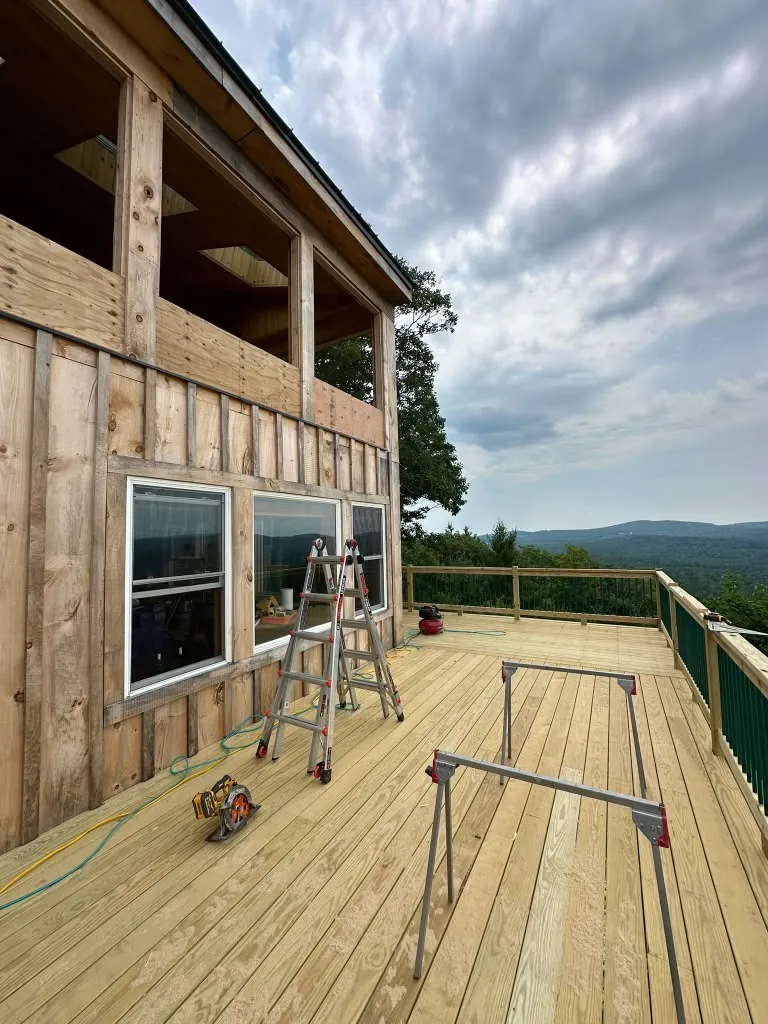 Large deck wrapping a two-story cedar-sided home