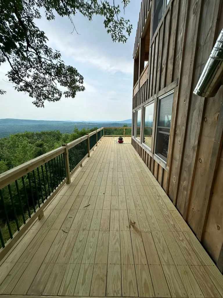 Wood deck with black railing and valley view