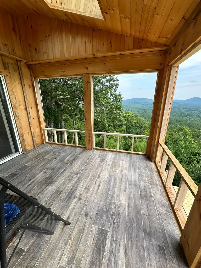 Screened porch with pine ceiling and wood railing